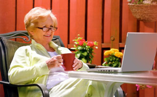 Senior using her computer in yard